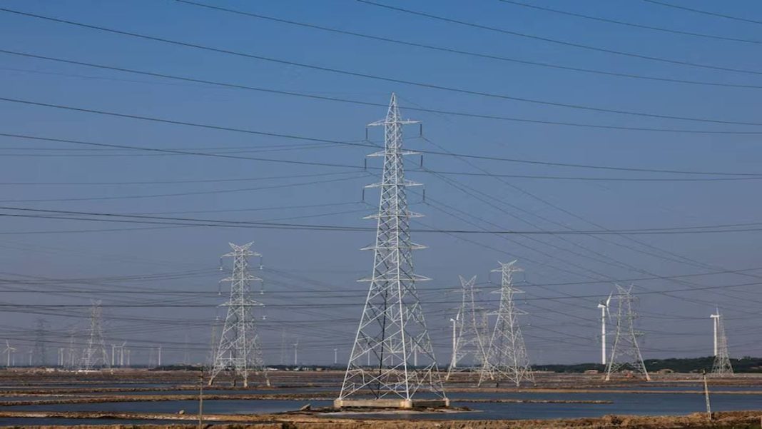 A view shows high-tension electricity power line pylons and power generating windmill turbines on Ahmedabad-Bhuj national highway near Surajbari village in the western state of Gujarat, India. (Photo source: Reuters)