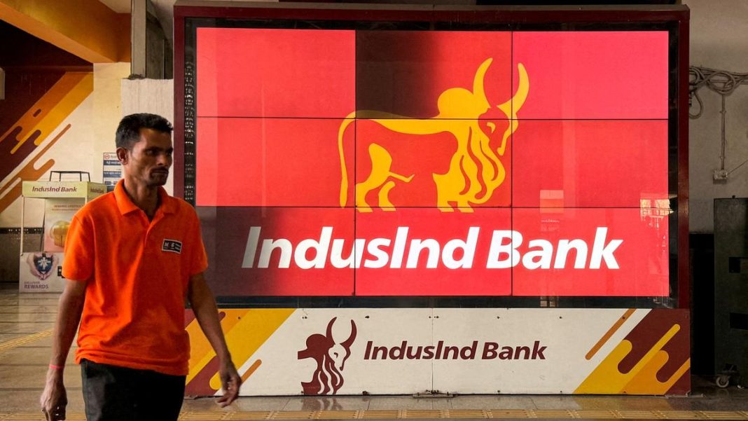 A man walks past a screen displaying the logo of IndusInd Bank at a metro station in New Delhi. File | Photo Credit: Reuters