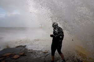 A woman is caught by a large wave at Blackrock diving tower during Storm Amy which brought severe weather. (Photo by Reuters)