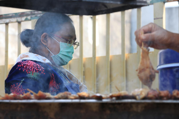 A grilled chicken vendor near Chao Pho Suea (Tiger) Shrine at Phra Nakhon, Bangkok. The Finance Ministry has a new scheme for small debtors. Apichart Jinakul