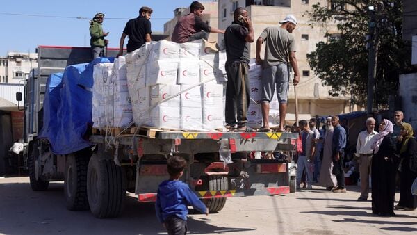 A truck loaded with humanitarian aid enters Deir el-Balah in the central Gaza Strip, more than a week after a ceasefire agreement between Israel and Hamas took hold, on October 18, 2025. (Photo by Bashar TALEB / AFP)