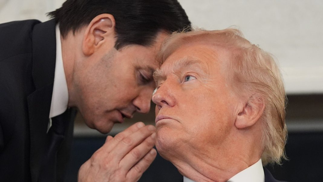 Secretary of State Marco Rubio whispers to President Donald Trump.