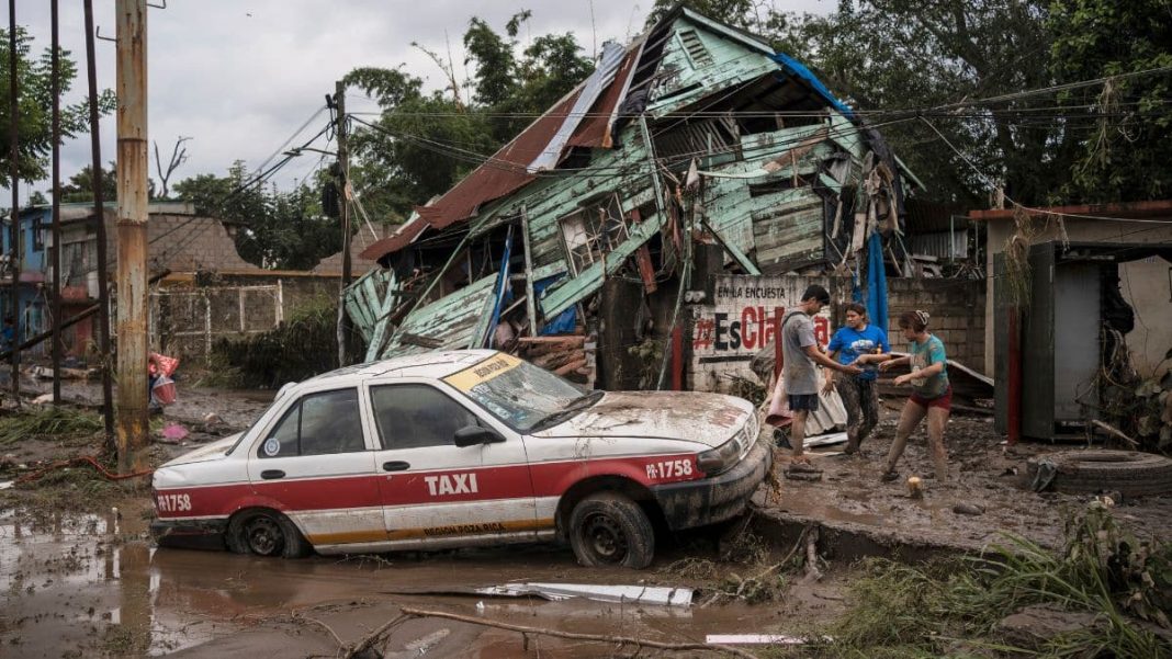 Neighbors gather around a damaged house after heavy rainfall in Poza Rica, Veracruz state, Mexico, Saturday, Oct. 11, 2025. (AP Photo)
