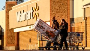 Black Friday shoppers walk out of Walmart with a full shopping cart on November 26, 2021, in Westminster, Colorado. (Michael Ciaglo/Getty Images)