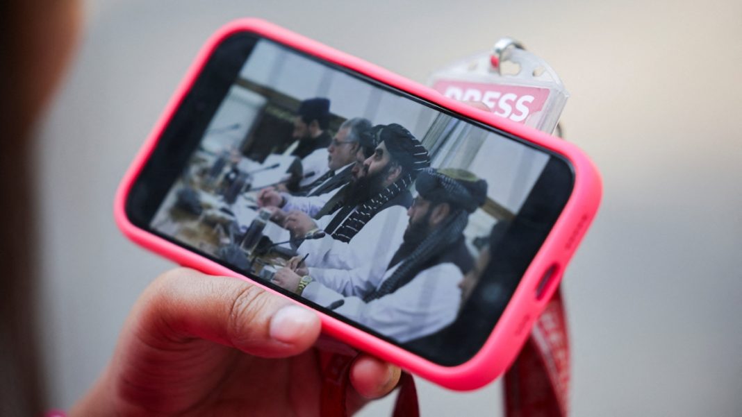 A journalist watches the live streaming of talks between Afghanistan's Foreign Minister Amir Khan Muttaqi and India's Foreign Minister S. Jaishankar | Reuters
