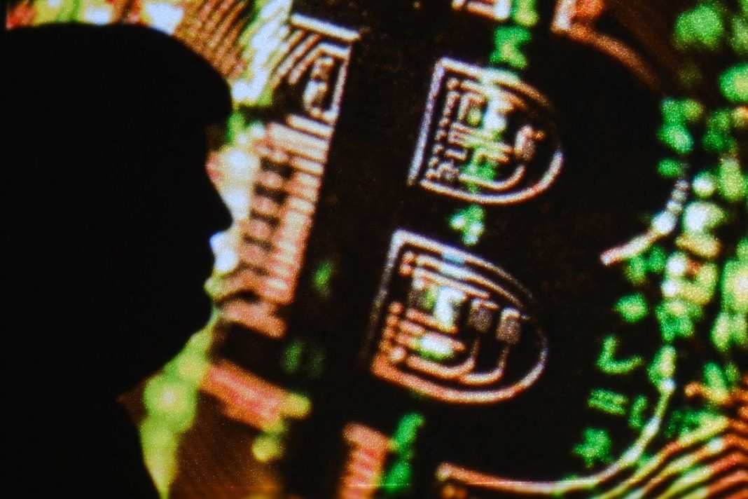 Silhouette of Donald Trump in front of a digital projection of bitcoin in Clermont-Ferrand France on 13 June 2025 (Romain Costaseca/Hans Lucas/AFP via Getty Images)