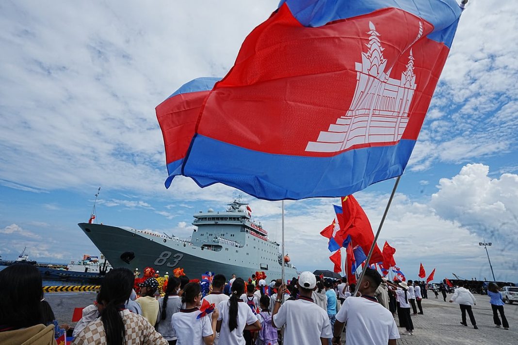 Chinese businessmen and local students gather as Chinese warship Qijiguang arrives at a commercial port in Sihanoukville, southern Cambodia, Friday, Oct. 10, 2025.