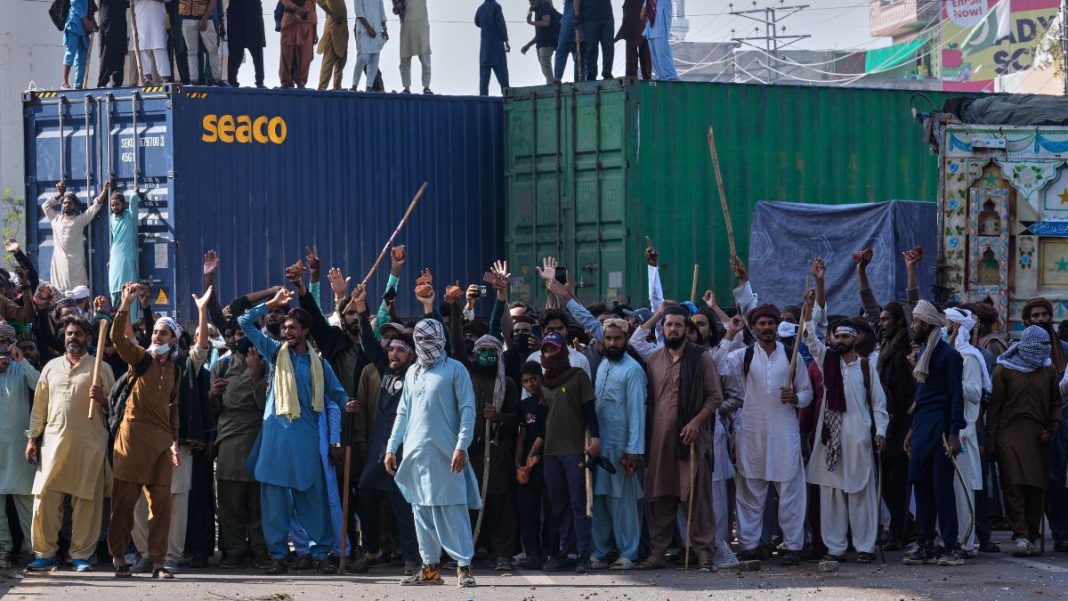 Supporters of Islamist party 'Tehreek-e-Labbaik Pakistan' chant religious slogans near their party's headquarters on a road barricaded with shipping containers by Pakistan's Punjab police | AP