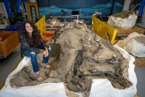Lindsay Zanno, head of paleontology at the North Carolina Museum of Natural Sciences, poses with the famed dueling dinosaurs fossil.