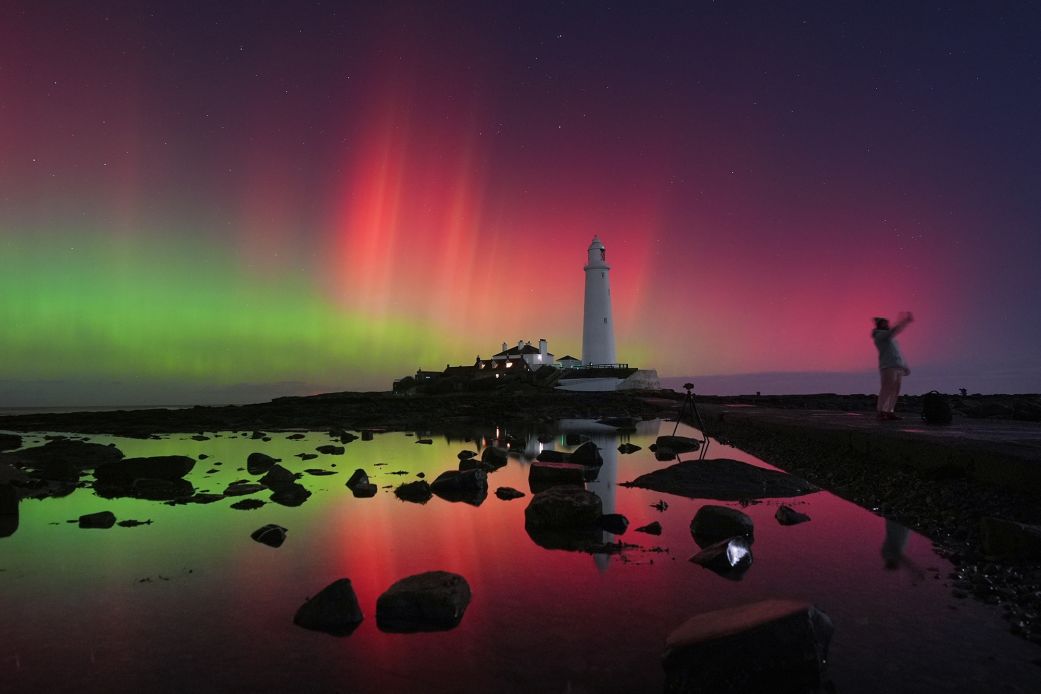 The aurora borealis, also known as the northern lights, glow in the sky on Wednesday over St. Mary's Lighthouse in Whitley Bay on England's northeast coast.