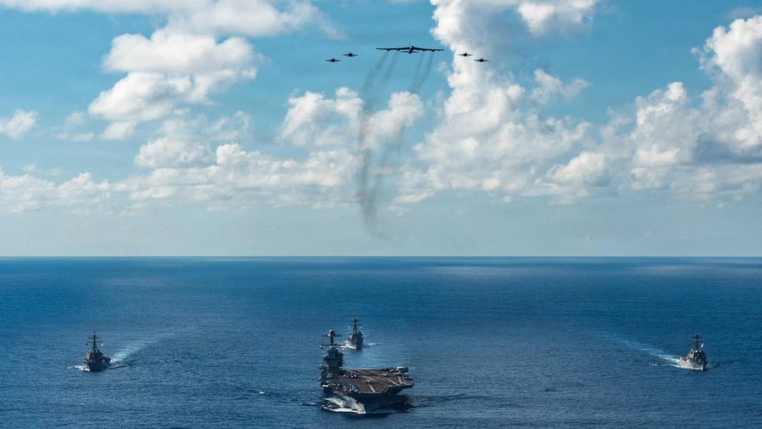 The U.S. Navy’s Gerald R. Ford Carrier Strike Group, including the flagship USS Gerald R. Ford, USS Winston S. Churchill, USS Mahan and USS Bainbridge, sail towards the Caribbean Sea under F/A-18E/F Super Hornets and a U.S. Air Force B-52 Stratofortress, in the Atlantic Ocean, on November 13, 2025. | Photo Credit: U.S. Navy via Reuters