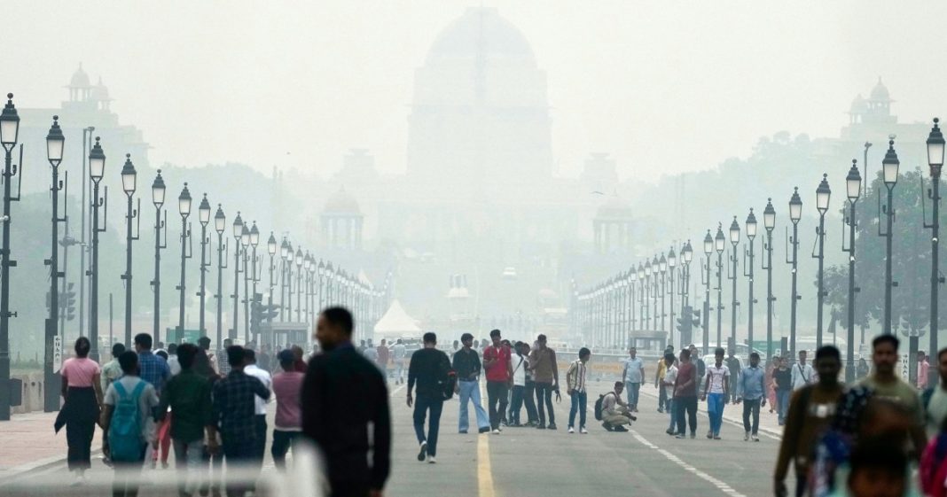 People walk on a street enveloped in smog in New Delhi on Tuesday.