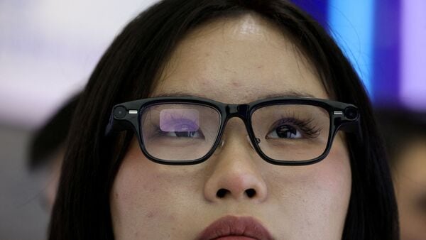 FILE PHOTO: A woman tries on a pair of Quark AI glasses by Alibaba at the company's booth at the expo of the World Internet Conference in Wuzhen town of Tongxiang city, Zhejiang province, China November 8, 2025. REUTERS/Tingshu Wang/File Photo