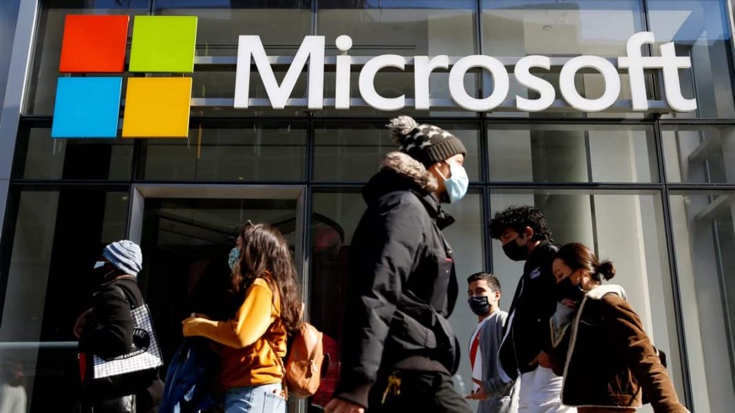 People walk past a building with the Microsoft logo. (Representative Image, Credit: Reuters)