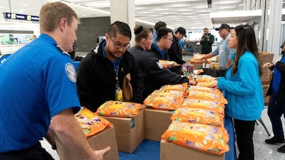 Transportation Security Administration (TSA) staff receive boxes of food at a mobile food pantry set up for TSA employees and other federal workers affected by the government shutdown, at the Minneapolis Saint Paul International Airport in Minneapolis, US. (IMAGE: REUTERS)