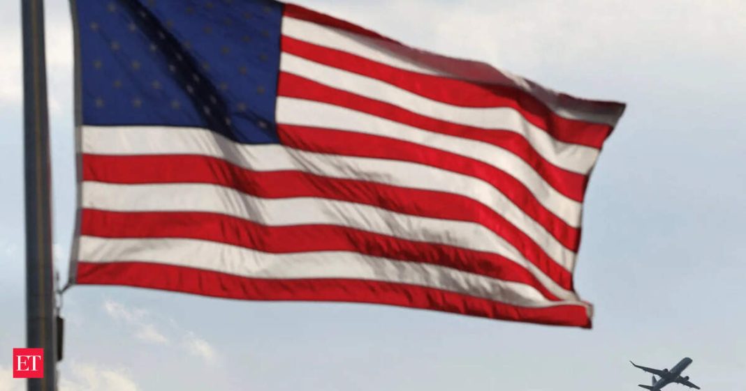 A plane flies past a flag at the Washington Monument as air travel turmoil deepened with thousands of flights delayed nationwide. (File image)