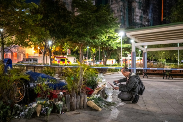 People have left flowers and cards of remembrance near Wang Fuk Court, the site of the deadly blaze