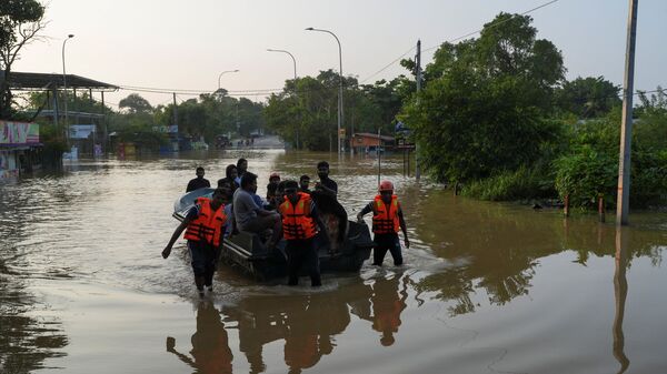 People ride on a boat belonging to Sri Lanka's army at a flooded area following Cyclone Ditwah in Kelaniya, Sri Lanka, November 30, 2025.