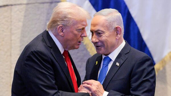 US President Donald Trump (L) holds hands and speaks with Israeli Prime Minister Benjamin Netanyahu at the Israeli parliament, the Knesset, in Jerusalem on October 13, 2025.