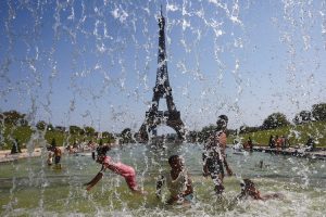 Children play in water on a sunny and warm summer day as a heatwave hits France. (Photo: Reuters)