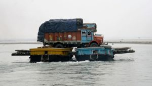 A truck loaded with paddy crop is transported through the waters of river Brahmaputra in Assam. (Photo: Reuters)