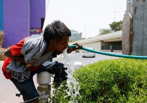 A man drinks water from a pipe during a hot summer day in New Delhi. (Photo: Reuters)
