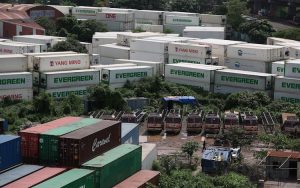 A number of trucks are parked in a line surrounded by containers. (Photo: Reuters)
