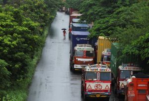 A man walks past trucks with shipping containers. (Photo: Reuters)
