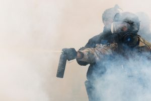 A security officer uses pepper spray through a cloud of tear gas in Oregon, US. (Photo: Reuters)