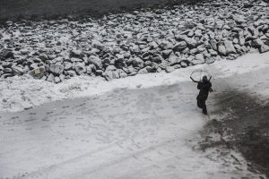 A pedestrian walks on a street as snow falls during a winter storm in New York City. (Photo: Reuters)