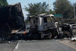 A charred truck blocks a road the day after the Mexican army killed Jalisco New Generation Cartel leader Nemesio Oseguera Cervantes, known as 'El Mencho,' in Guadalajara, Mexico, Monday, Feb. 23, 2026. (AP Photo/Marco Ugarte)