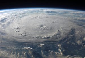 An aerial view of Earth with a massive swirling hurricane. (Photo: Pexels)
