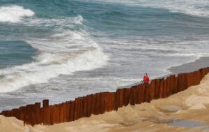 A woman walks past Coogee beach in Australia where sea levels are rising. (Photo: Reuters)