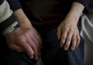A man holds hands with his wife who was diagnosed with dementia. (Photo: Reuters)