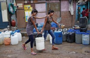 Girls carry a water container after filling it from a municipal tanker in New Delhi. (Photo: Reuters)