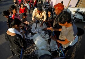 A man distributes ice amongst slum residents during hot weather in Ahmedabad, India. (Photo: Reuters)