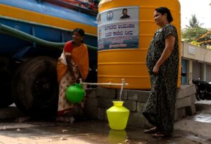 Residents fill their containers with drinking water from water tanks. (Photo: Reuters)