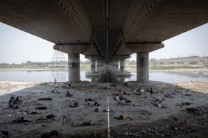 People sleep on the Yamuna river bed under a bridge on a hot summer day in New Delhi. (Photo: Reuters)