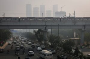 Traffic moves past residential buildings under construction, shrouded in heavy smog in Noida. (Photo: Reuters)