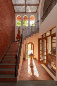 The staircase is adorned with traditional patterned tiles on the risers and a classic wrought-iron railing.