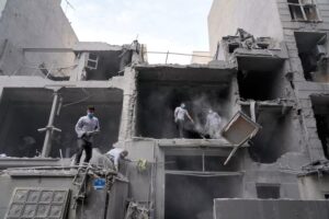 Volunteers clean debris from a residential building in Tehran (AP)