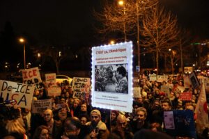Protesters hold a sign reading 'This is America. The America we all love, admire, and need to support' over a photograph taken by photographer Marc Riboud in 1967 of anti-Vietnam War protesters in the United States, at a rally against Trump in Paris in January 2026. (AFP File Photo)