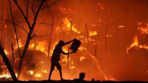 A man throws water onto a fire that broke out in a slum area in the eastern Indian city of Bhubaneswar. (Photo: Reuters)