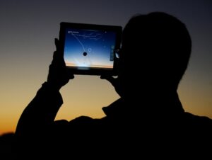 A man using an app on an iPad to line up the passing comet. (Photo: Reuters)