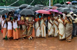 Teachers and schoolchildren hold umbrellas as it rains. (Photo: Reuters)