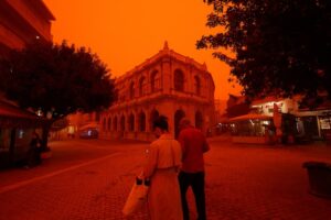 People walk amid a haze caused by sand dust from in Heraklion, Crete island. (Photo: Reuters)