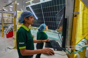 Workers check the quality of a solar panel at a ReNew manufacturing plant near Jaipur. (Photo: AP)