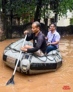 A man moves through a flooded street on a floatable object. (Photo: ITG)