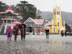 Pedestrians hold umbrellas during a hailstorm, in Shimla. (Photo: PTI)