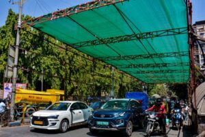 Vehicles ply under a green shade installed to provide relief from the heat in Thane. (Photo: PTI)